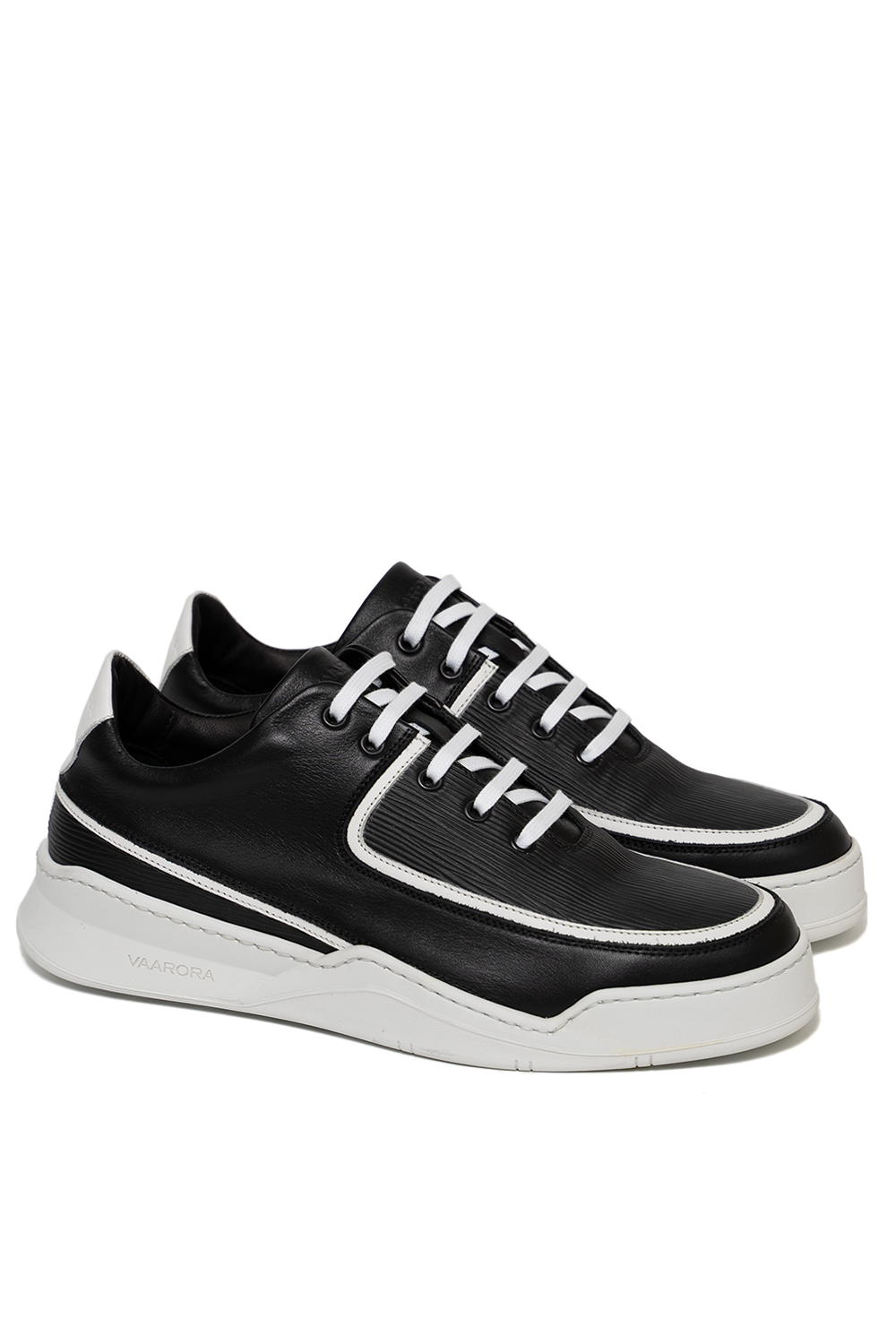 Side view of the Vaarora Aaron Low Top luxury sneaker showcasing smooth and textured black leather, striking white piping, and a heavy-weight white rubber sole