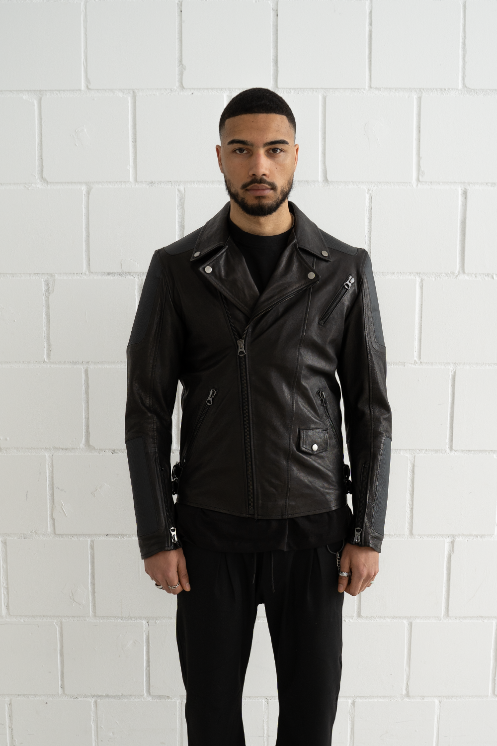 Front view of a male model wearing the tailored Vaarora Manu biker jacket in black