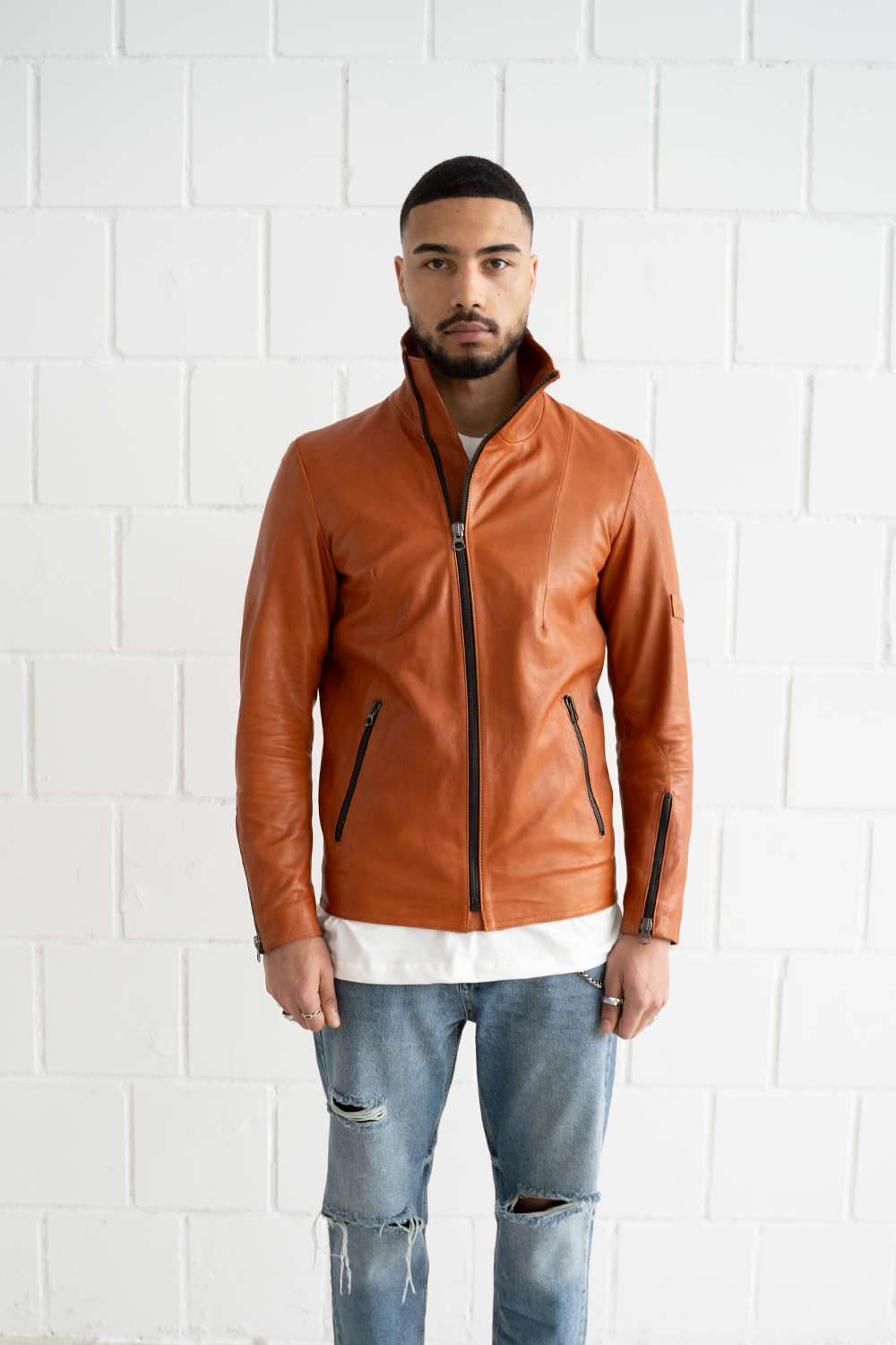 Front view of the Vaarora asymmetrical camel leather jacket highlighting the distinctive diagonal zipper and slim fit