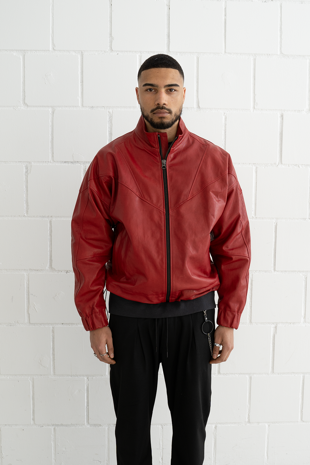 Front view of a male model wearing the Vaarora Vittorio oversized leather jacket in red with adjustable waistband