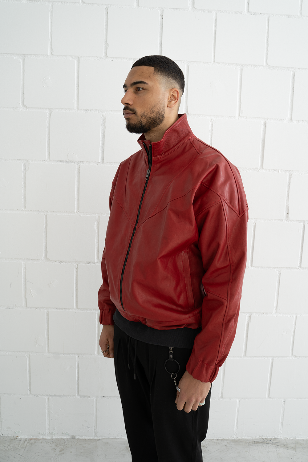 Side view of the red Vaarora Vittorio leather jacket showcasing the relaxed fit, stand-up collar, and elasticated cuffs